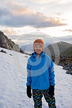 Child, boy, enjoying snow on mount Hoven, splendid view over Nordfjord from Loen skylift