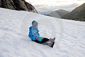 Child, boy, enjoying snow on mount Hoven, splendid view over Nordfjord from Loen skylift