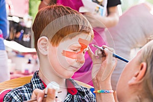 Child boy face painting, making tiger eyes process