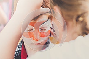 Child boy face painting, making tiger eyes process