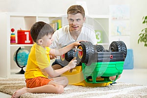 Child boy and father repair toy car