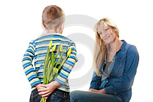 Child boy giving flowers his mother