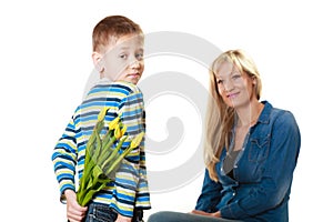 Child boy giving flowers his mother