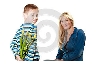 Child boy giving flowers his mother