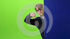 Child boy in glasses appears from the side of the board holding her hands in front on a green screen. Slow motion