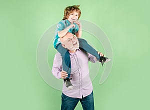 Child boy and grandfather with funny face isolated piggyback ride. Elderly old relative with child.