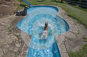 Child boy at guitar-shaped swimming pool, Losar de la Vera, Spain