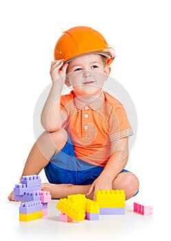 Child boy with hard hat playing with toys