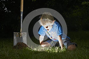 Child boy have unearthed a treasure in the grass photo