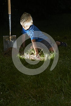 Child boy have unearthed a treasure in the grass photo