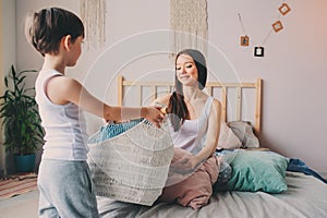 child boy helps mother to clean the room in the morning