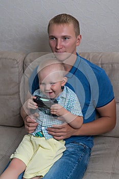 Child boy and his father play with a playstation together