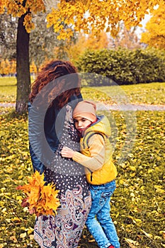 Child boy with his mother in autumn park outdoors