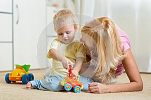 Child boy and his mother repair toy car at home