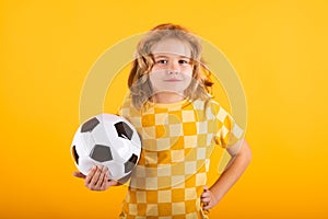 Child boy hold classic soccer ball isolated on yellow studio. Kid holding football ball in studio. Kid playing with ball