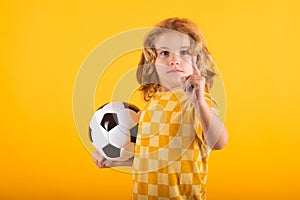 Child boy hold classic soccer ball isolated on yellow studio. Kid holding football ball in studio. Kid playing with ball