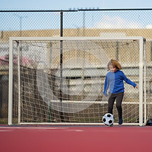 Child boy hold classic soccer ball on playground. Kid holding football ball in studio. Kid playing with ball. Sport