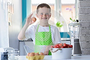 Child boy holding egg.