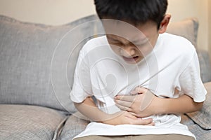 Child boy holding his stomach,kid suffering from stomachache,abdominal disease,pain ache in belly,Problem with intestine,distended photo
