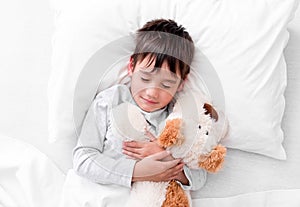 Child boy holding plush toy while sleeping