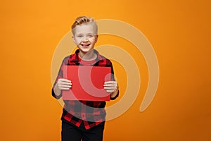 Child boy holding a red sign with space for text.