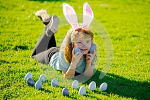 Child boy hunting easter eggs. Cute kid having fun in park. Easter egg hunt concept. Spring kids holidays concept.