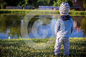 Child boy looking to lake water