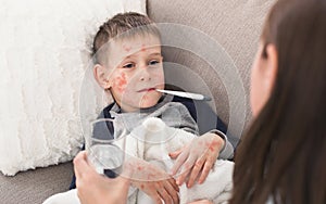 Child Boy With Measles Measuring Temperature, Lying on Sofa