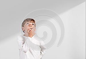 Child boy pensive portrait looking up on copy space white background