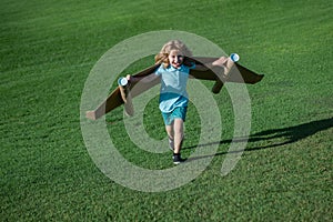 Child boy playing with cardboard toy airplane wings craft in sky with copy space for text. Creative with family and