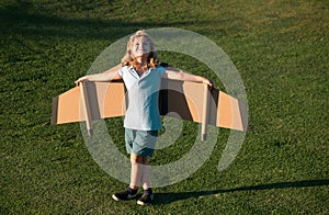 Child boy playing and dreaming about summer vacation and travel. Kids imagination and freedom concept. Little boy dream