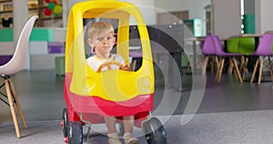 Child boy playing driving toy car indoors playcenter. Educational toys for child