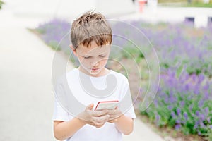Child boy playing mobile games on his smartphone