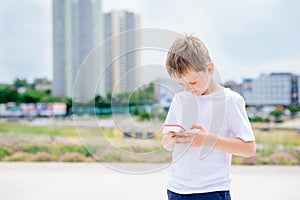 Child boy playing mobile games on his smartphone