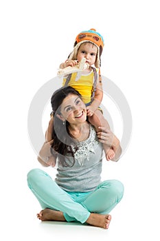 Child boy plays pilot sitting on mother shoulders