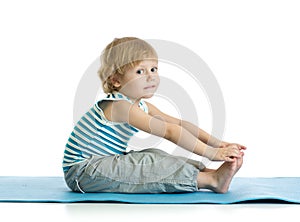 Child boy practicing yoga, stretching in exercise. Kid isolated over white background