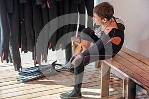 child boy puts on a wetsuit and prepares to dive. Boy Scuba Diver