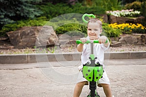 Child boy riding a trike in the park