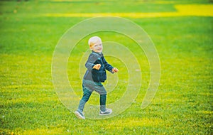 Child boy run in spring or summer field. Kid at park. Childhood activity, leisure, lifestyle concept.