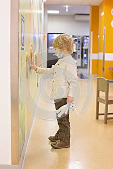 Child, boy, sitting in the waiting room in emergency, waiting for examination