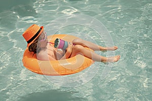 Child boy splashing in swimming pool. Swim water sport activity on summer vacation with children.