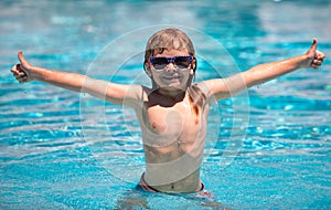 Child boy swim in swimming pool. Children play in tropical resort. Family beach vacation. Kids learn to swim.