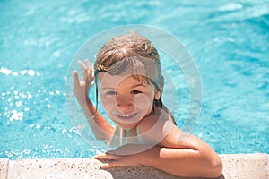 Child boy swim in swimming pool. Happy little kid boy playing with in outdoor swimming pool on hot summer day. Kids