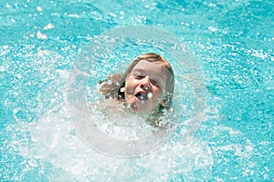 Child boy swim in swimming pool. Splash water. Little boy playing in outdoor swimming pool in water on summer vacation