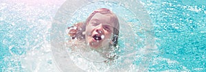 Child boy swim in swimming pool. Splash water. Little boy playing in outdoor swimming pool in water on summer vacation