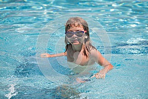 Child boy swim in swimming pool. Summertime and swimming activities for children on the pool. Portrait of cute kid boy