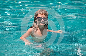 Child boy swim in swimming pool. Summertime and swimming activities for children on the pool. Portrait of cute kid boy
