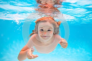 Child boy swim under water in sea. Kid swimming in pool underwater. Happy boy swims in sea underwater, active kid