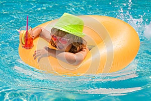 Child boy in swimming pool with inflatable toy ring. Kids swim on summer vacation. Swim for child on float. Beach sea