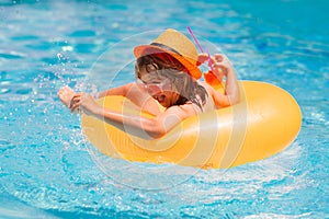 Child boy in swimming pool. Little kid boy having fun in the pool. Outdoor summer activity for children. Child floating